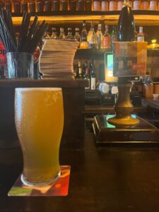 A pint of Brehon Blonde next to the hand pump