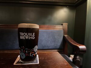 A pint of Trouble Dark Arts on a table