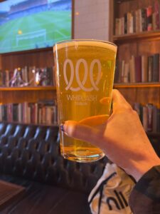A pint of Whiplash with books behind